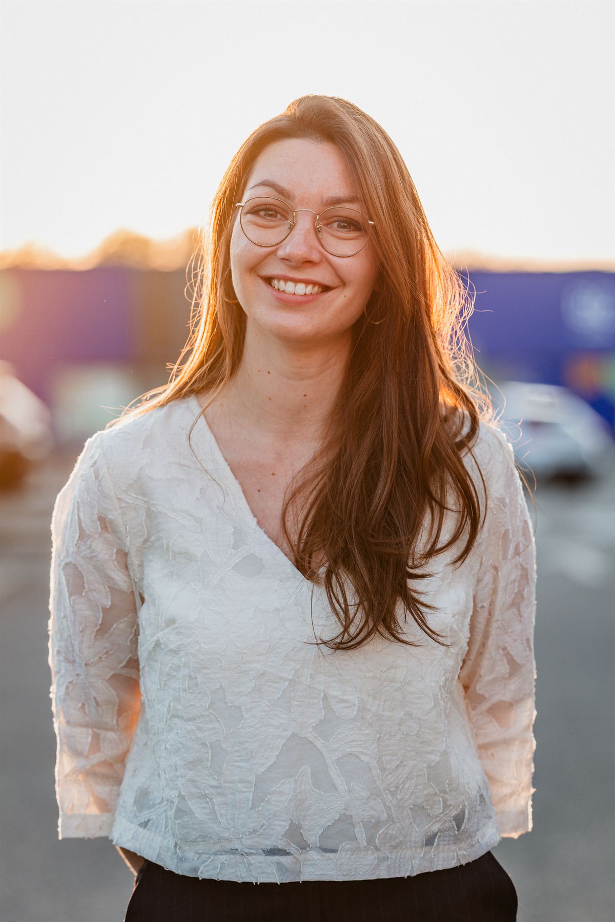 Portrait professionnel d'une femme souriante à lunettes, lumière du soir