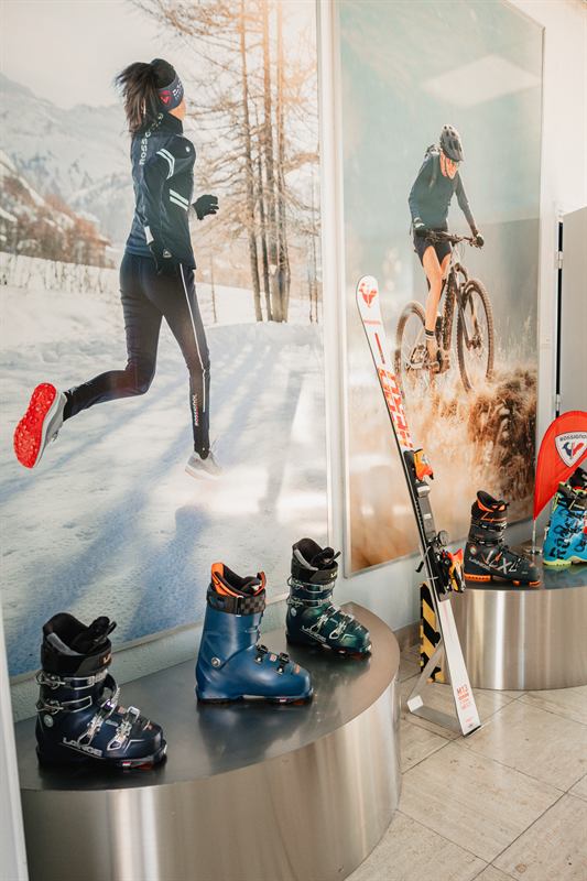 Chaussures de ski exposées dans un showroom devant une grande affiche