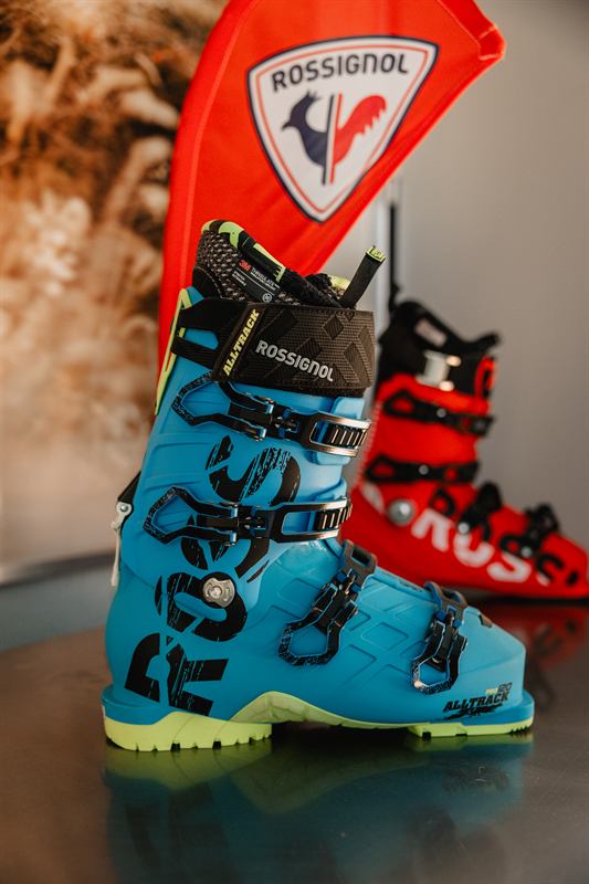 Chaussure de ski bleue devant un drapeau Rossignol