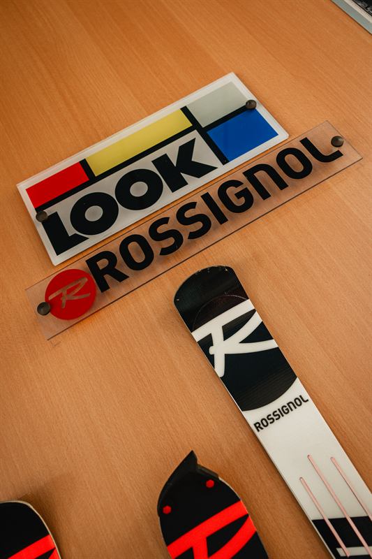 Plaque Look Rossignol et skis posés sur une table en bois