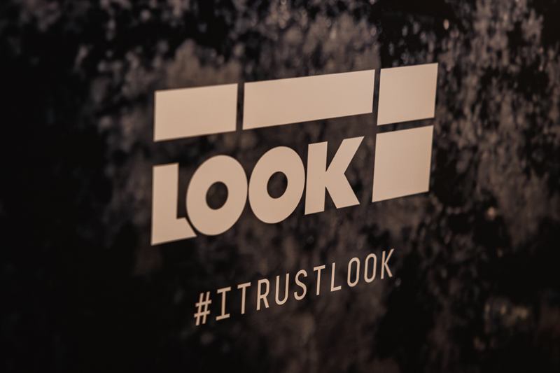 Logo Look et slogan sur un mur sombre