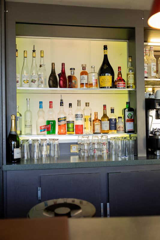 Étagères de bouteilles éclairées derrière le bar
