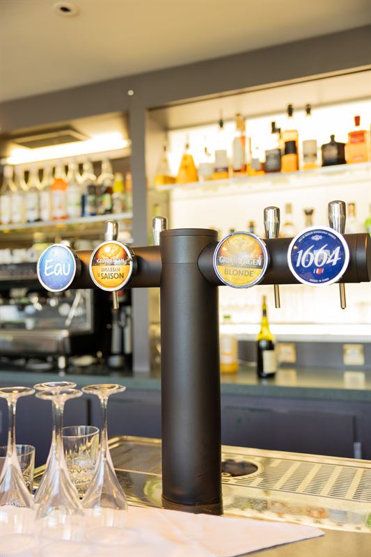 Tireuse à bière et verres à pied sur le comptoir d'un bar