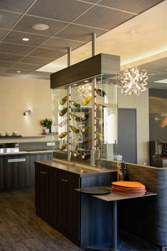 Salle de petit déjeuner d'hôtel avec cave à vin vitrée