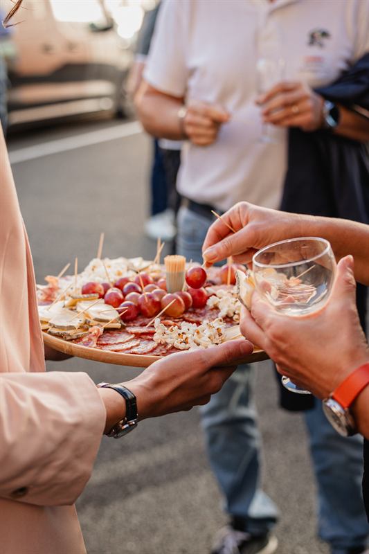 Invités se servant sur un plateau de charcuterie et fromages