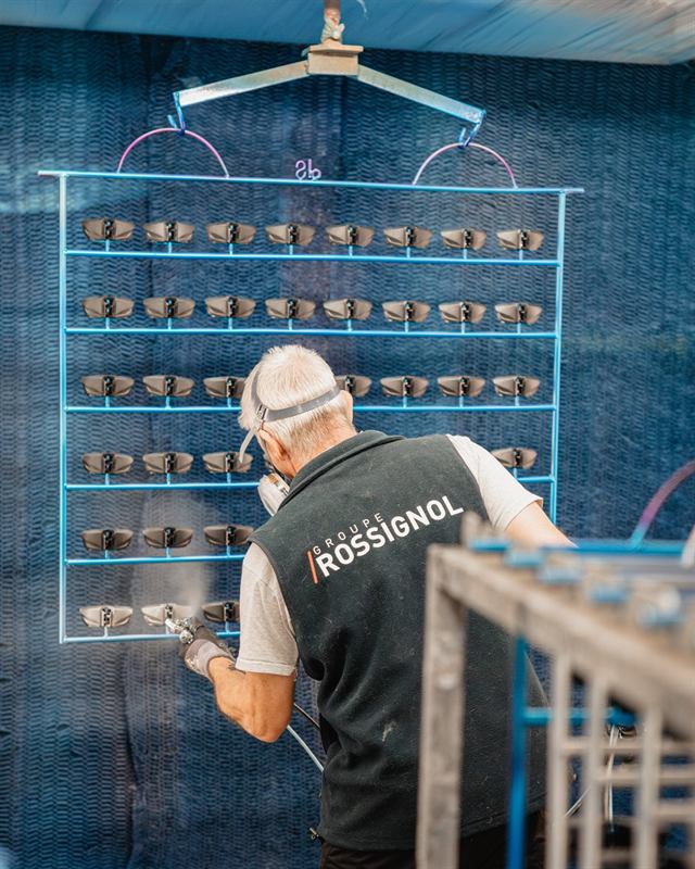 Technicien Rossignol à son poste devant un mur de pièces