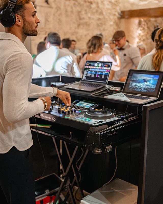 DJ aux platines devant les invités d'une soirée