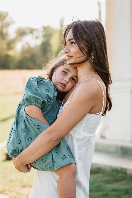 Maman serrant sa fille dans ses bras, fin de journée