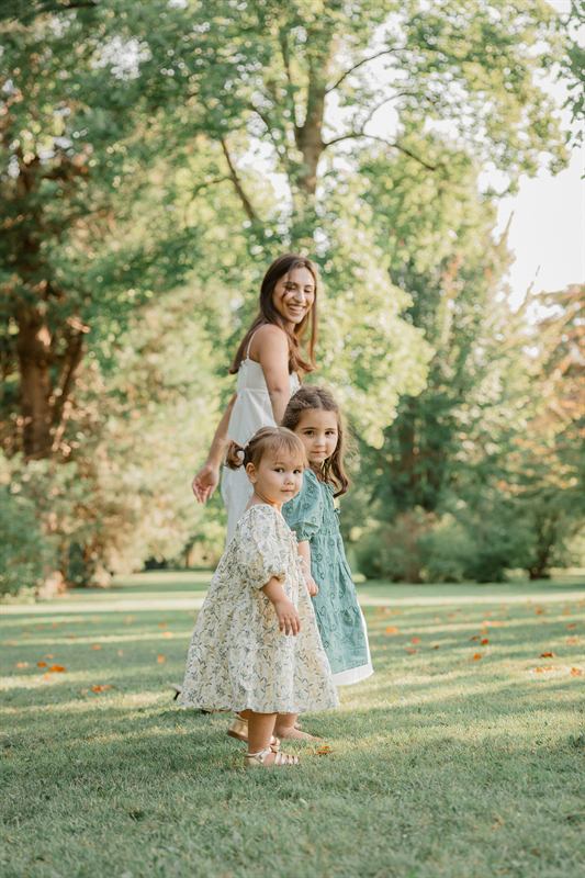Maman et ses deux filles sous les arbres d'un parc