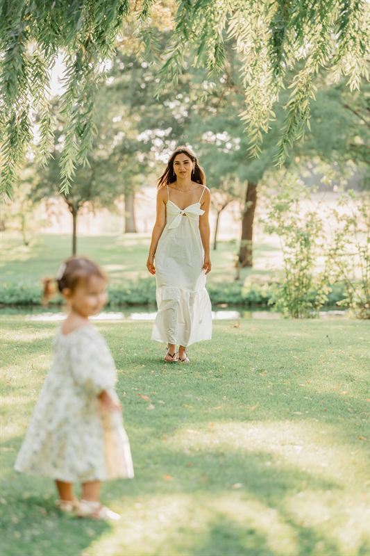 Petite fille marchant vers l'objectif, sa maman derrière elle