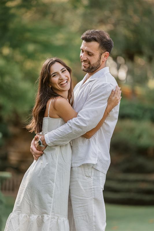 Couple enlacé et riant dans un jardin