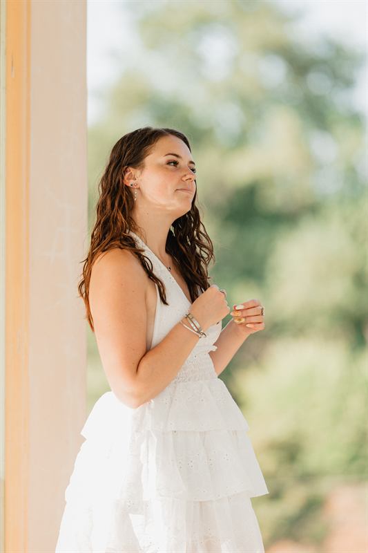 Portrait d'une jeune femme en robe blanche, à l'ombre d'une colonnade