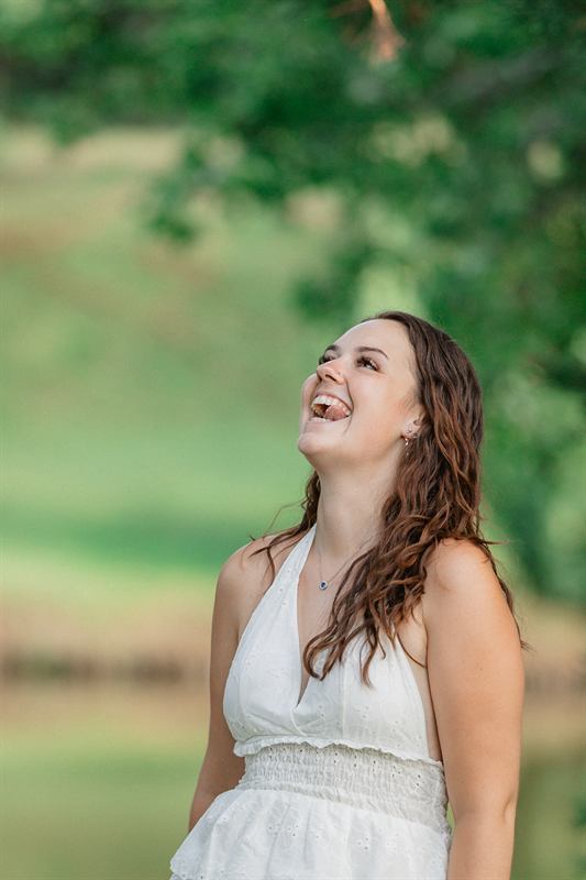 Jeune femme riant aux éclats, portrait en extérieur