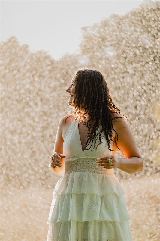 Jeune femme de profil sous une pluie fine éclairée par le soleil