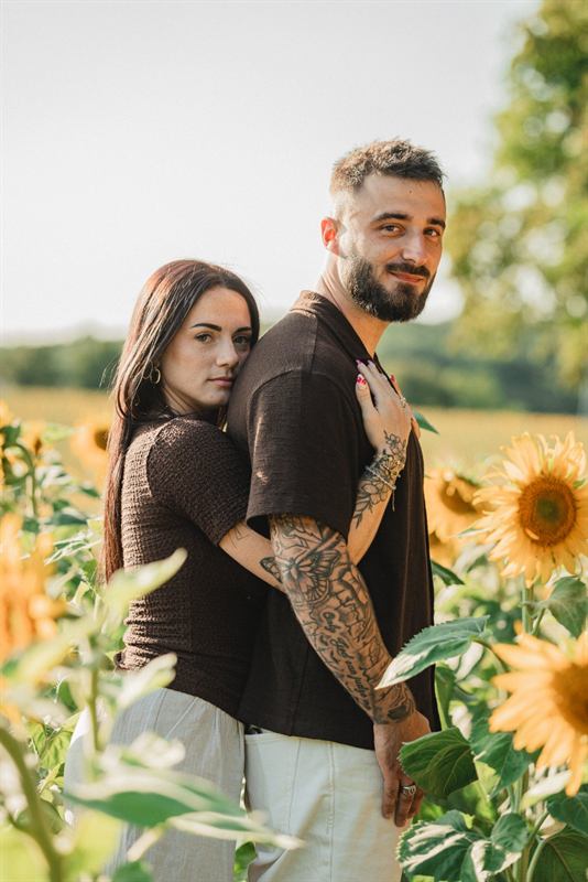 Couple regardant l'objectif au milieu des tournesols