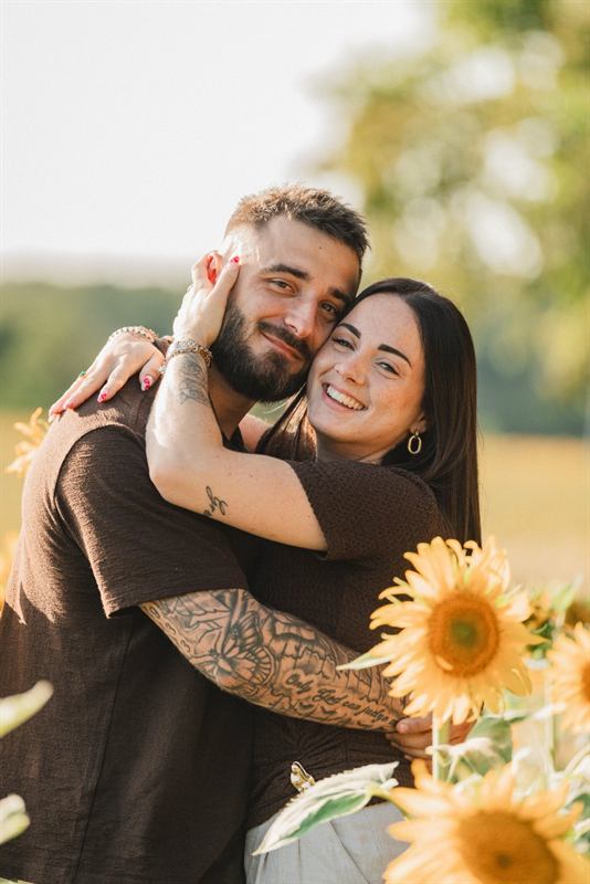 Couple joue contre joue dans les tournesols, fin d'été