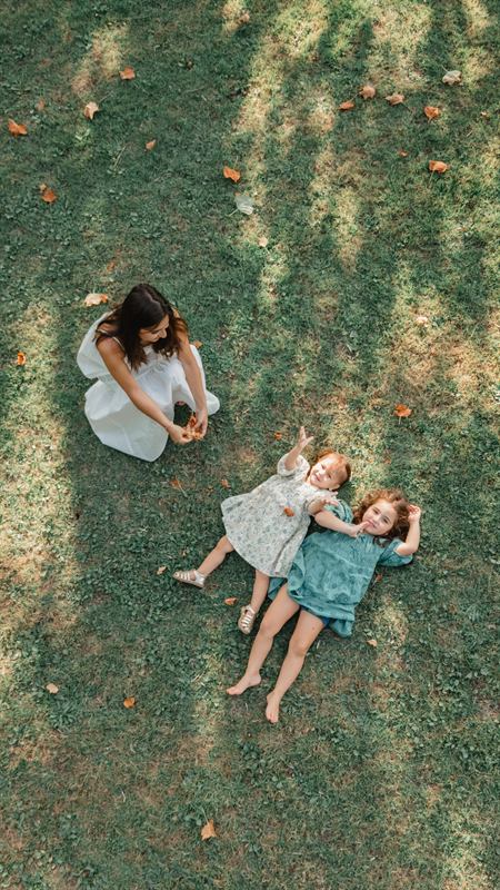 Maman et ses filles allongées dans l'herbe, vue du dessus